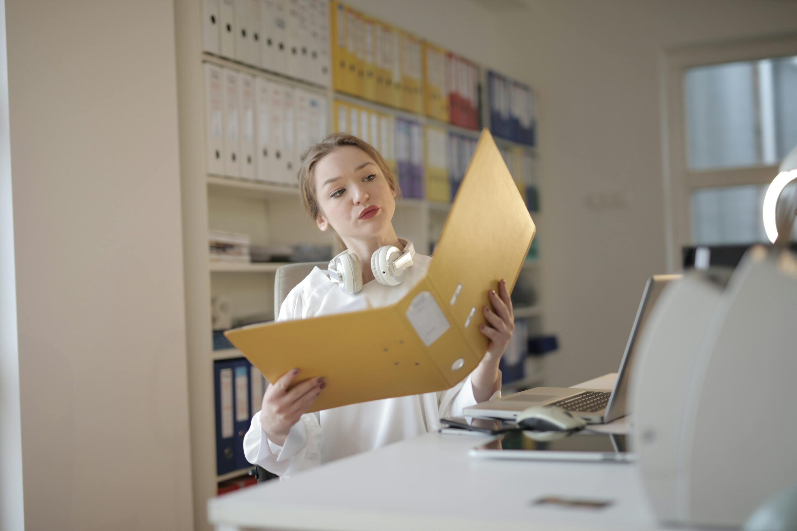 A person sitting at a desk looking overwhelmed with piles of paper around them