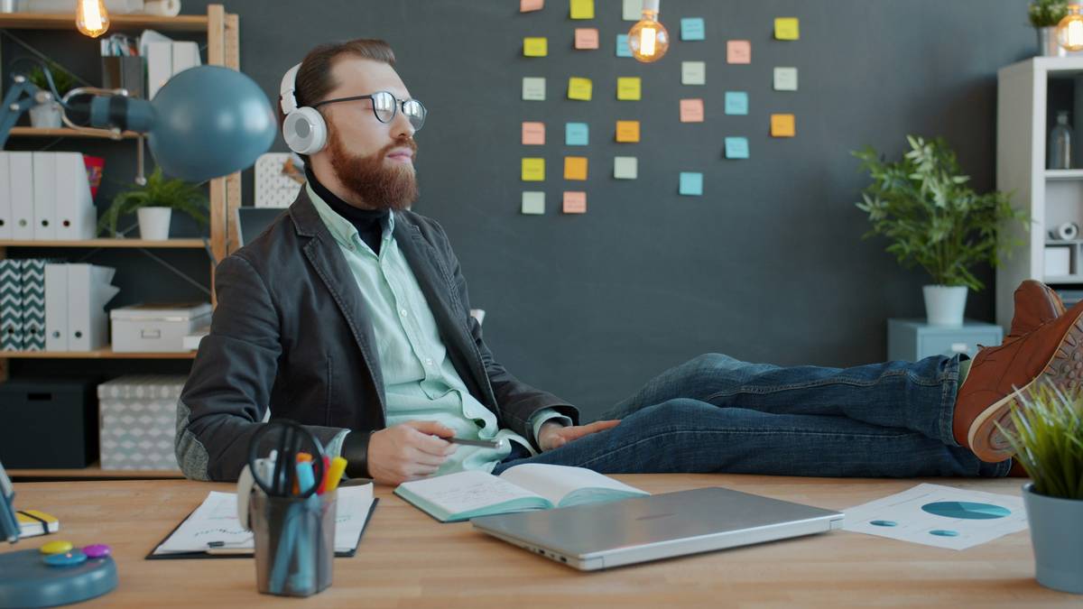 Man walking a golden retriever during lunch break near park bench.