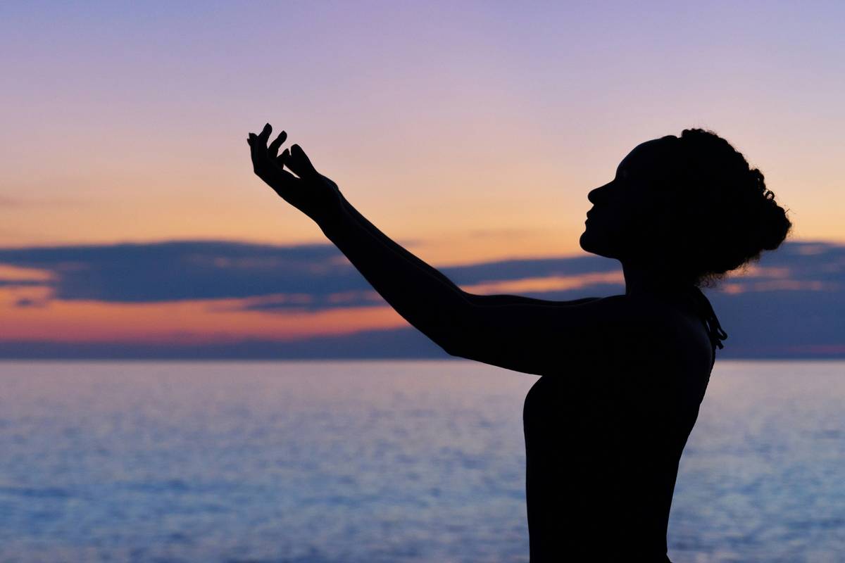 A person sitting cross-legged in peaceful meditation by a serene lake