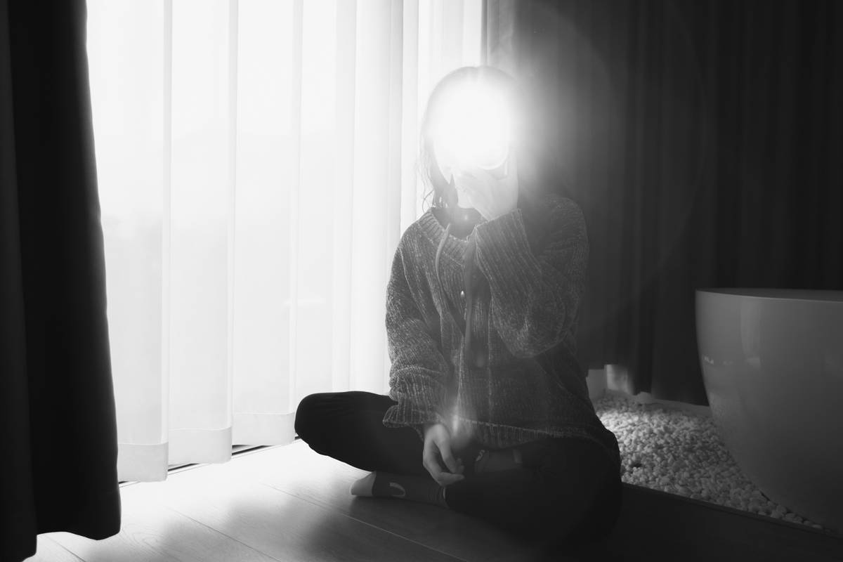daily zen simple habit quiet moment: person sitting calmly by a window at sunrise with eyes closed